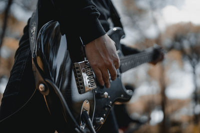 Midsection of man playing guitar