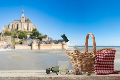 Table and chairs in basket against blue sky