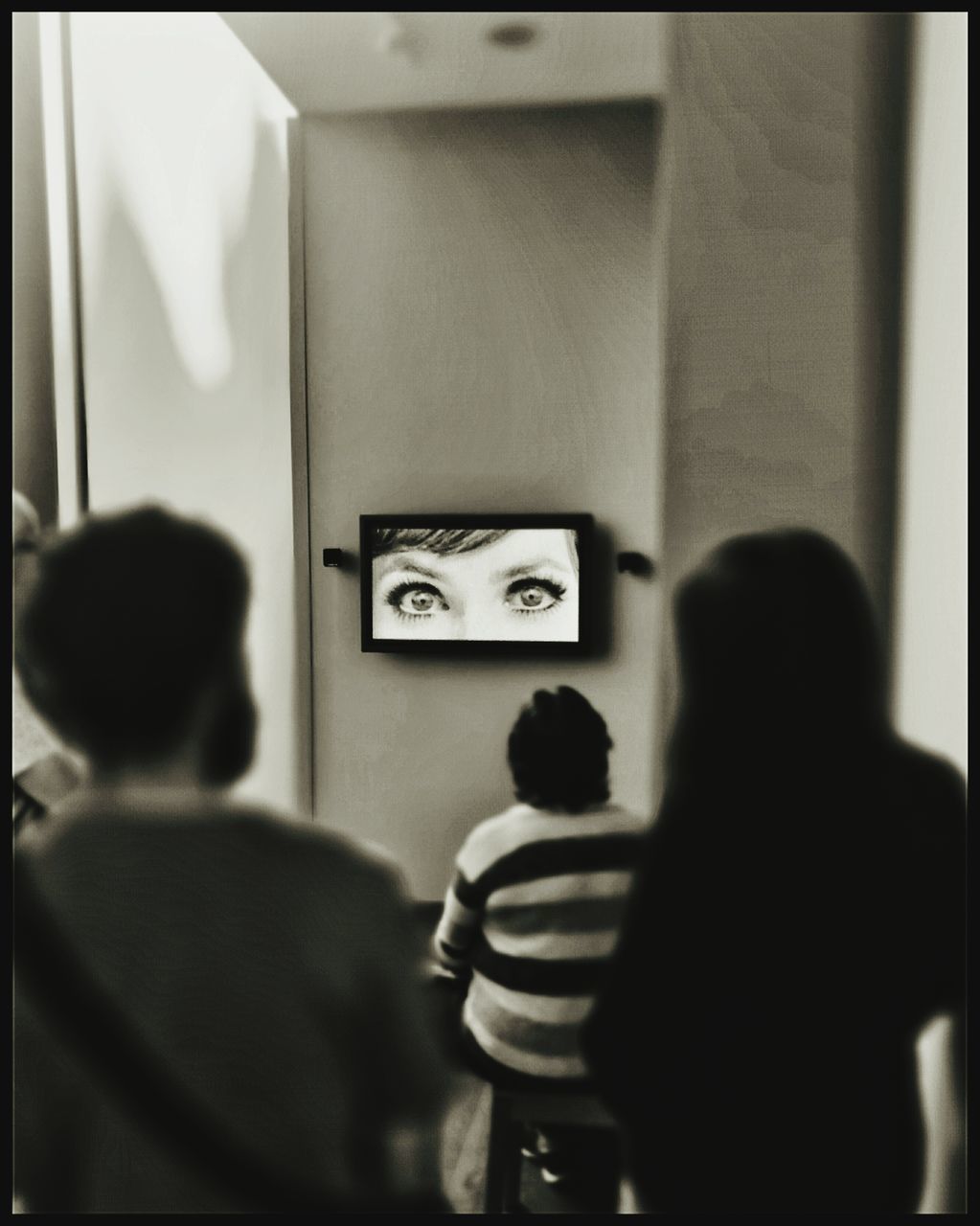 REAR VIEW OF PEOPLE LOOKING AT CAMERA THROUGH CAR