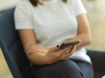 Midsection of woman using mobile phone