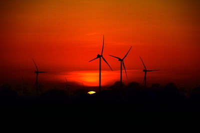 Scenic view of sunset and windmills