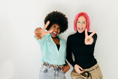 Portrait of friends standing against white background