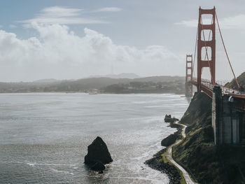 View of bridge over sea against cloudy sky