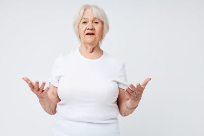 Portrait of young woman standing against white background