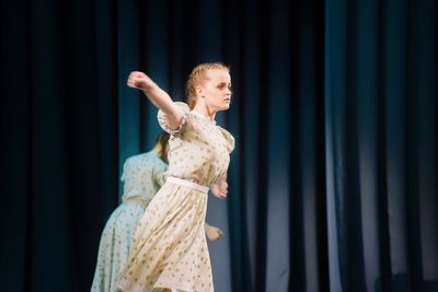 Side view of young woman performing on stage