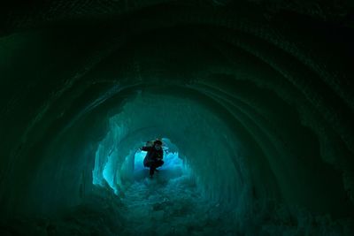 Man in frozen cave during winter