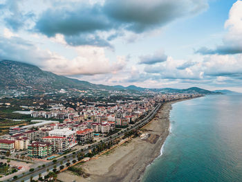 High angle view of city by sea against sky