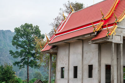 Low angle view of red roof and building against sky