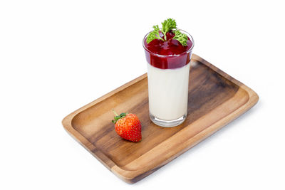 Close-up of strawberry and fruits on cutting board against white background