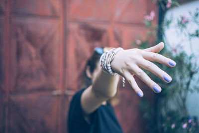 Close-up of young woman showing fingernails with nail polish