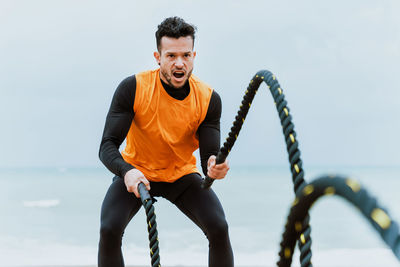 Man doing battle rope outdoors