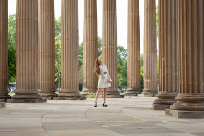 Full length of woman standing against building