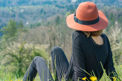 Rear view of woman sitting on mountain