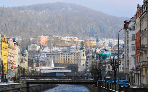 Aerial view of buildings by street in city during winter