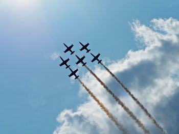 Low angle view of silhouette airplane flying against sky