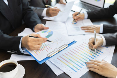 Midsection of business people working on table