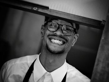 Portrait of cheerful young man seen through window