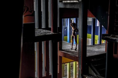 Woman standing by glass building