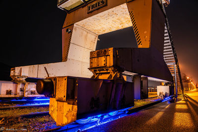 Illuminated factory against clear blue sky at night