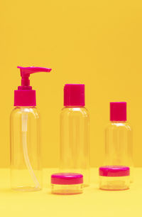 Close-up of bottles against yellow background