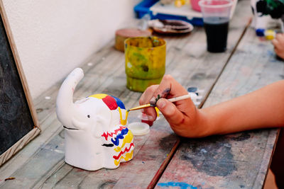 Midsection of woman painting on table