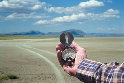 Man photographing on field against sky