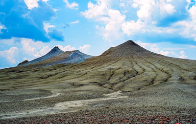 View of volcanic landscape against cloudy sky