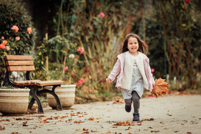 Full length of smiling girl running at park