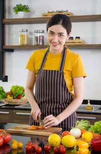 Portrait of a smiling young woman standing at market stall