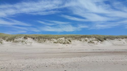 Scenic view of desert against blue sky