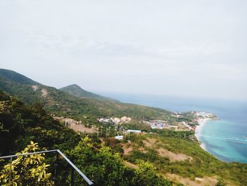 Aerial view of townscape by sea against sky