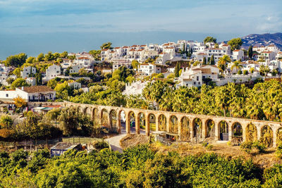 Townscape with aqueduct against sky on sunny day