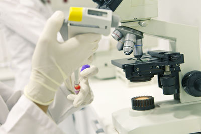 Cropped image of scientist performing experiment in laboratory