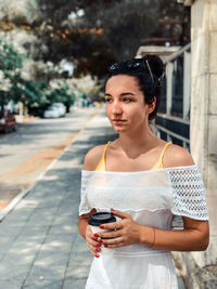 Portrait of beautiful woman standing in city