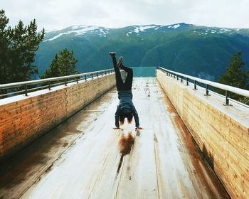 Man on railing against mountain