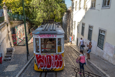 People walking on street amidst buildings in city