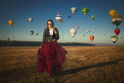 Full length of woman with balloons on field