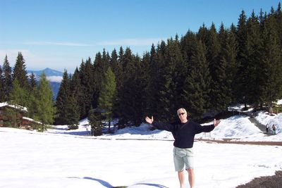 Full length of woman standing on snow covered trees
