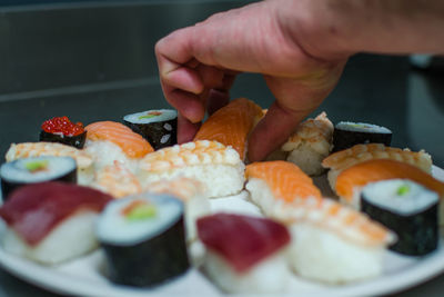 Cropped image of person preparing sushi