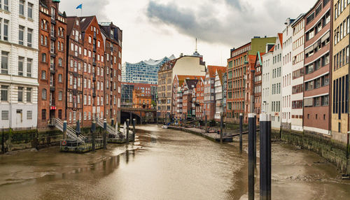 Canal amidst buildings against sky in city