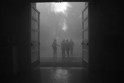 Rear view of silhouette people walking in corridor of building
