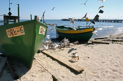 Boats moored on beach against sky