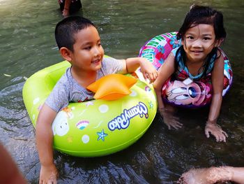 High angle view of siblings enjoying in river