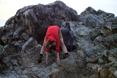 Female hiker exercising on rocks