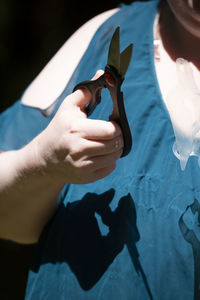 Midsection of woman holding scissors