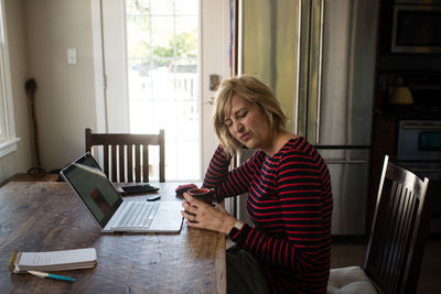 Young woman using mobile phone at home