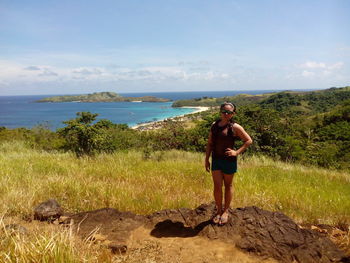 Portrait of woman standing on hill against sea at calaguas island