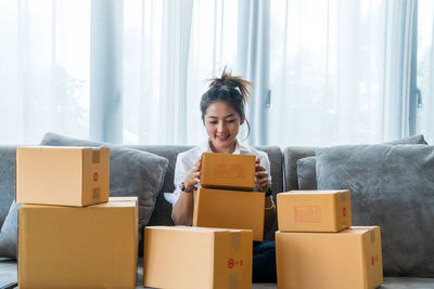Young woman smiling while sitting in box