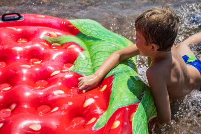 High angle view of shirtless boy in water