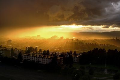 High angle view of cityscape against cloudy sky during sunset